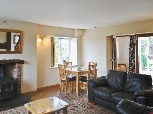 a living room with a couch and a table at Dragon Fly Cottage in Brompton