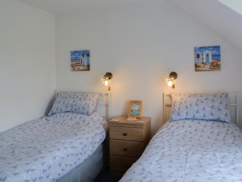 dos camas sentadas una al lado de la otra en un dormitorio en Dragon Fly Cottage en Brompton