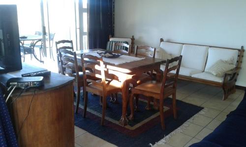 a dining room with a table and chairs and a couch at Swansnes in Stilbaai