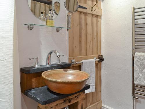 a bathroom with a wooden sink and a mirror at Brynhoreb in Llanilar