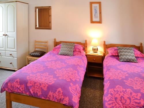 a bedroom with two beds and a dresser at Manacle View in Saint Keverne
