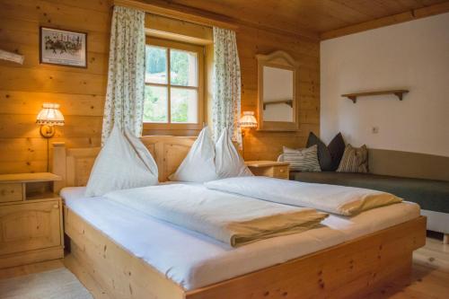 a bedroom with a large bed in a wooden room at Pension Schmiderer - Vorderkasbichlhof in Saalfelden am Steinernen Meer