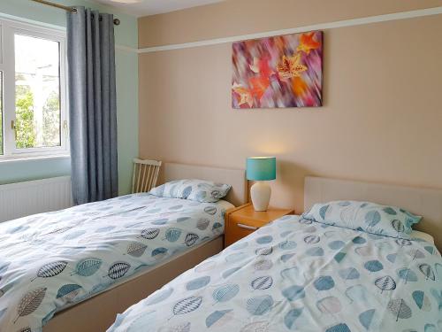 een slaapkamer met 2 bedden en een schilderij aan de muur bij Sandringham Heights in Paignton