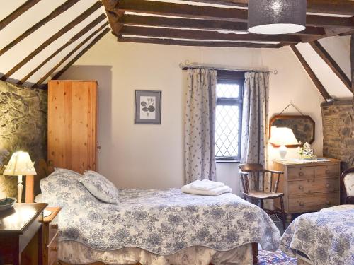 a bedroom with a bed and a dresser and a window at Mollys Cottage in Knighton