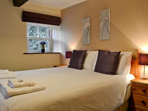 a bedroom with a large white bed with a window at The Granary in Carperby