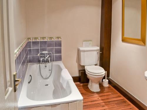 uma casa de banho com uma banheira branca e um WC. em The Granary em Carperby