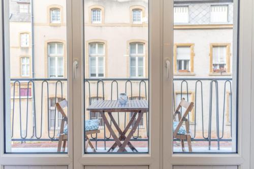 a table and chairs on a balcony with a view of a building at Casa Pestana in Metz