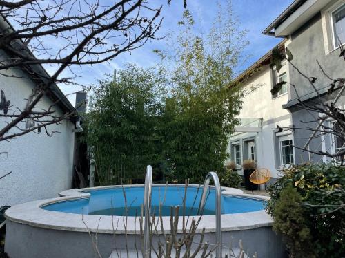 a swimming pool in a yard next to a house at Cheap Outlet Center Apartment with Pool in Parndorf