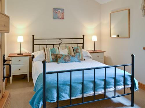 a bed in a bedroom with two night stands and two lamps at The Hayloft in Great Ormside