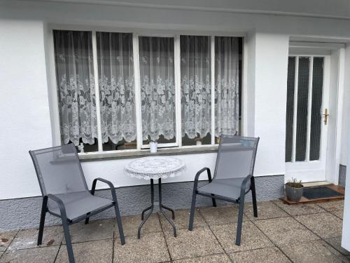 two chairs and a table in front of a window at Cheap Outlet Center Apartment with Pool in Parndorf