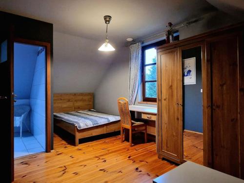 1 dormitorio con cama, escritorio y ventana en Nad Bystrą en Nałęczów