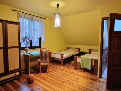 1 dormitorio con 2 camas, mesa y ventana en Nad Bystrą en Nałęczów