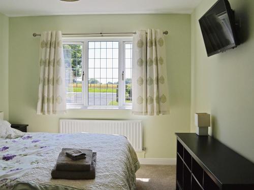 um quarto com uma cama e uma janela em Clydesdale em North Somercotes