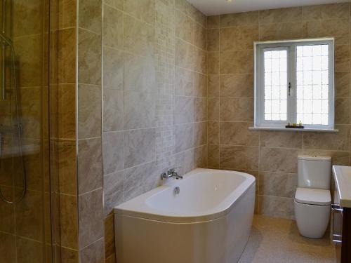 uma casa de banho com uma banheira, um WC e um lavatório. em Clydesdale em North Somercotes