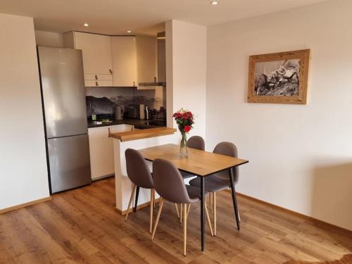 a kitchen with a table and chairs and a refrigerator at Phils Apartment in Rettenberg