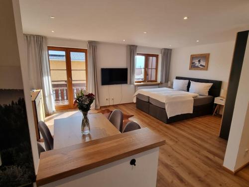 ein Hotelzimmer mit einem Bett und einem Tisch mit einem sidx sidx in der Unterkunft Phils Apartment in Rettenberg