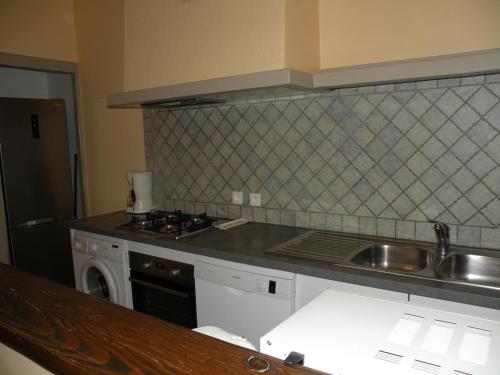 une cuisine avec un évier et une cuisinière four supérieur dans l'établissement Le cypres aux esperifes, à Vidauban