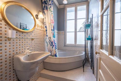 y baño con bañera, lavabo y espejo. en Le Cedre Bleu en Bourges