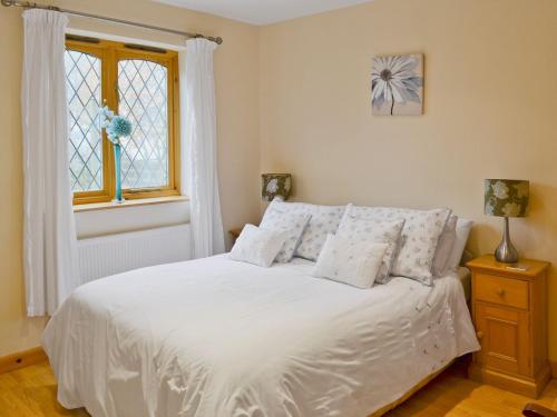 a bedroom with a bed with white sheets and a window at Beech Cottage - E4779 in Atwick