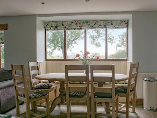 a dining room with a table and chairs and a window at Higher Paradise in Gisburn