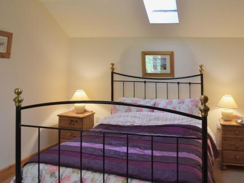 a bedroom with a black bed and two night stands at Bluebell Cottage in Alburgh