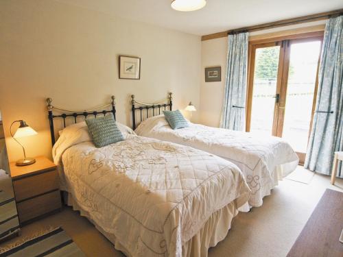 two beds in a bedroom with a window at Little Gable in Berrington