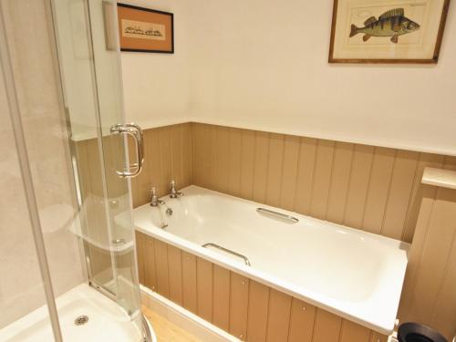 a bathroom with a bath tub and a shower at Little Gable in Berrington
