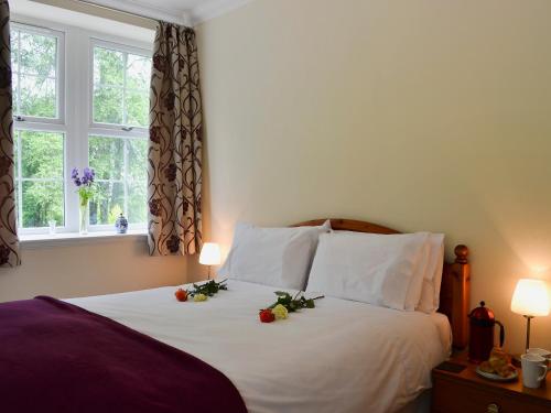 a bedroom with a bed with flowers on it at Laundry Cottage in Achlain
