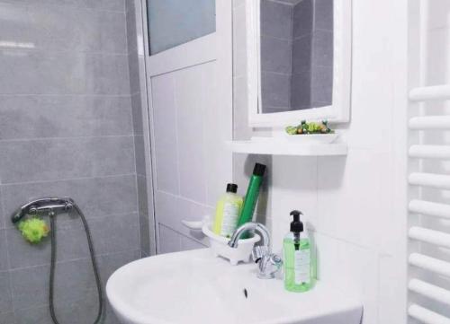 ein weißes Bad mit einem Waschbecken und einer Dusche in der Unterkunft Studio, quartier calme 10 min de l'aéroport Tunis Carthage , cité la Gazelle, près du Technopark in Jafar
