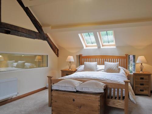 a bedroom with a large bed and two windows at Hendre Barn Mawr in Abergynolwyn