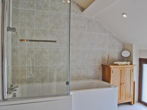 a bathroom with a shower with a tub at Hendre Barn Mawr in Abergynolwyn