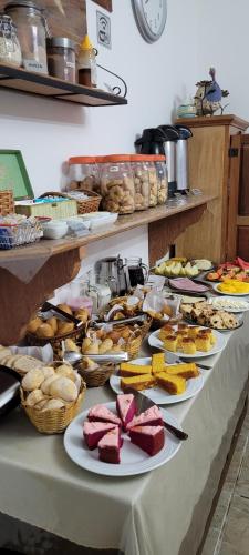 una mesa larga con platos de comida. en Pousada Amaryllis, en Tiradentes