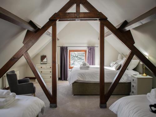 a attic bedroom with two beds and a window at Whitehouse Farm in Hartington
