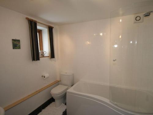 クロムフォードにあるThe Secret Cottageの白いバスルーム(トイレ、バスタブ付)