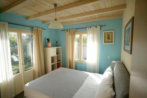 a bedroom with a white bed and two windows at Seaside Cottage in Kato Daratso