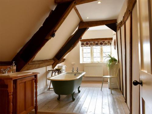 a bathroom with a bath tub and a sink at Churchill Cottage in Holwell