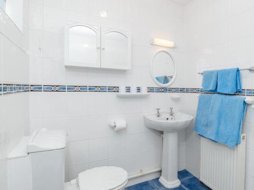 a white bathroom with a toilet and a sink at Cockington Bay Fort in Torquay