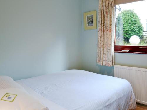 a bedroom with a white bed and a window at Briarwood in Bowness-on-Windermere