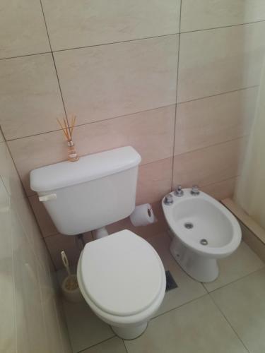 y baño con aseo blanco y lavamanos. en Kyomu Departamento en Macachín