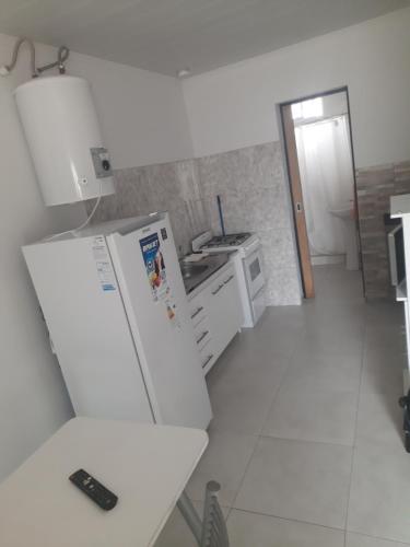 a kitchen with a white refrigerator and a sink at Kyomu Departamento in Macachín