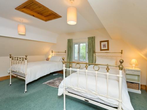 1 dormitorio con 2 camas y ventana en Coach House, en Wareham