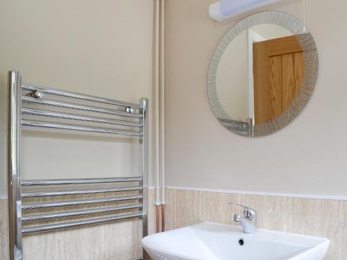 a bathroom with a sink and a mirror at Dolview in Penybont