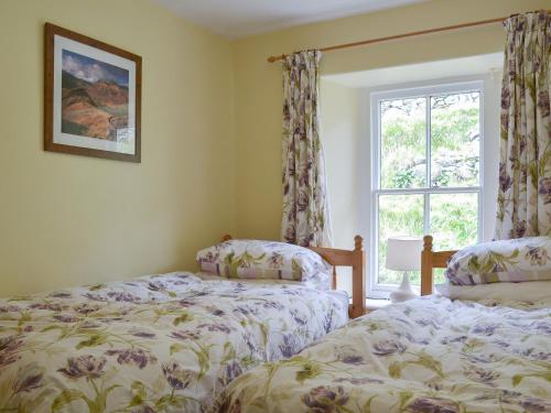 two beds in a room with a window at 3 Highrake in Glenridding