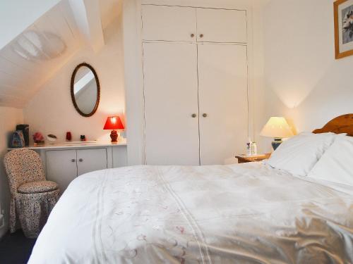 a bedroom with a white bed and a mirror at Sunnyside in Sandsend
