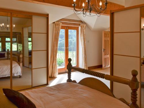 a bedroom with a bed and a large mirror at Lee Cottage in Heptonstall