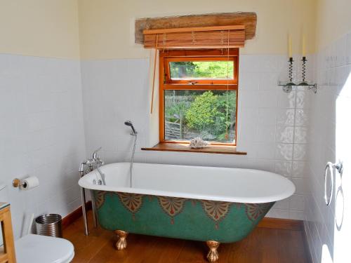 a bath tub in a bathroom with a window at Lee Cottage in Heptonstall