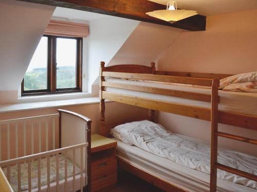 a bedroom with two bunk beds and a window at Hideaway in Brompton Ralph