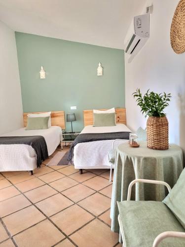 a room with two beds and a table with a plant at Casa da Mae in Salir