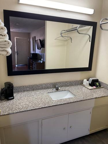 a bathroom with a sink and a large mirror at AMERICAN INN Stevenson in Stevenson
