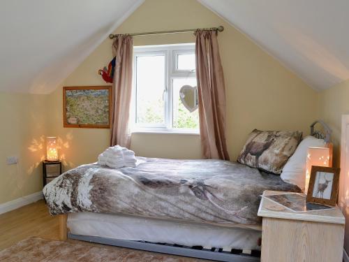 1 dormitorio con cama y ventana en Mill Haven, en Dunster